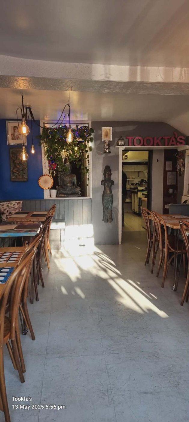 Tookta's dining room — warm Edison bulbs, wooden tables and Thai décor